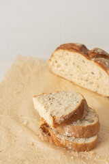 Loaf of homemade bread with sliced bread from wheat and seeds on parchment paper