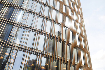 Wide angle background image of graphic glass building front against clear sky with reflection in windows, copy space