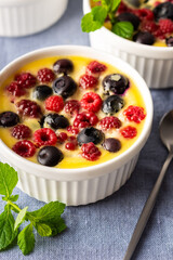 Delicious clafoutis made from white yogurt and berries, raspberries and blueberries, clafoutis in portioned bowls on the table