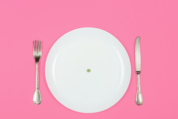 Diet, anorexia and food crisis concept. one pea on an empty white plate