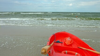 Fototapeta premium Red baywatch boat on beach. Rescue boat for emergency alert. Slowmotion.