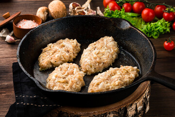 Chicken cutlets in a pan on a dark concrete table background