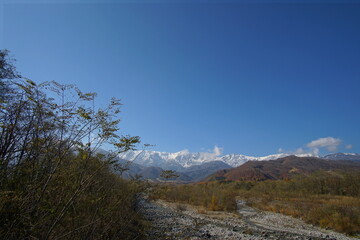 Fototapeta na wymiar autumn landscape with snow covered mountains in Japanese alps