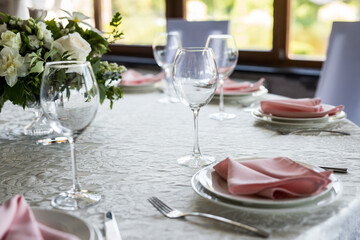 Close up festive table setting with empty wine glasses and white plate