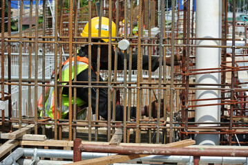 MALACCA, MALAYSIA -MAY 16, 2016: Construction workers fabricating steel reinforcement bar at the construction site in Malacca, Malaysia. The reinforcement bar was ties together using tiny wire.  
