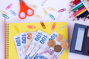 Colorful school supplies on white surface with calculator and Turkish money.Conceptual image of school expenses
