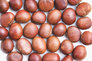 Roasted sweet chestnuts on white plate top view background