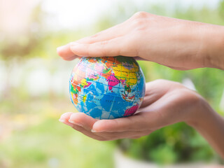 Close up hand woman holding globe on blur image background. for save the environment.