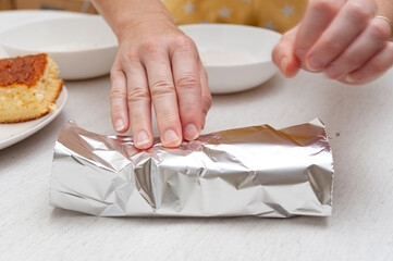 Traditional Brazilian dessert (known as Bolo Gelado) - Making step by step: Woman hand wrapping...