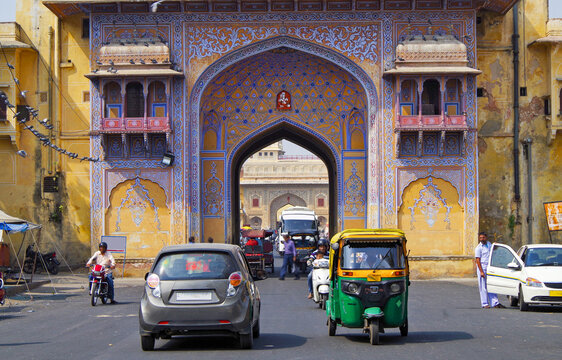 Street scene with traffic of cars and tuk tuks inside City Palace Jaipur Rajasthan India