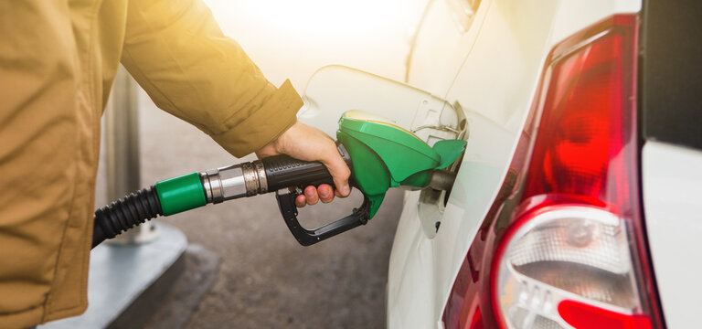 Man Inserts A Refueling Nozzle In The Tank Car At A Self Service Gas Station