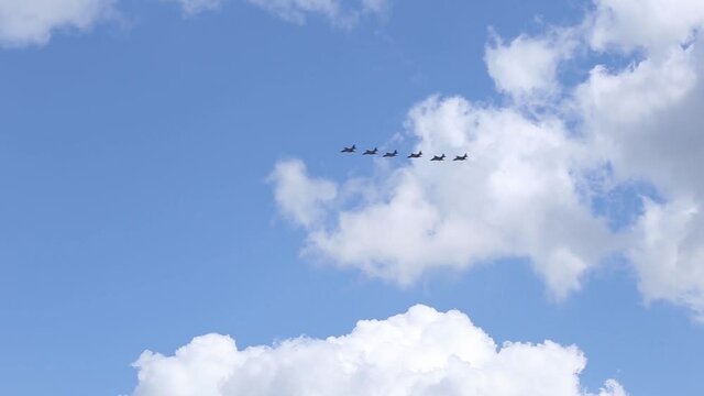 fighter jets cross the cloudy sky in a slim line