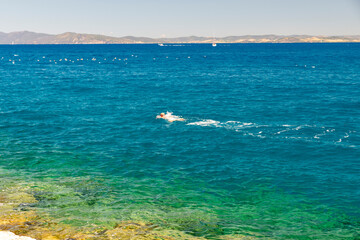 man swimming in the sea in porto santo stefano