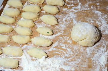 Dough on a Board with flour and pies. Cooking homemade hotcakes with onion and egg filling.
