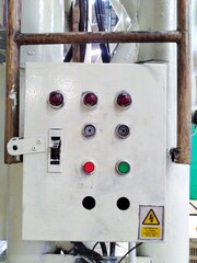 Light control cabinet for turning on and off the industrial machinery, with yellow warning sticker.