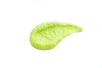 A drop of wasabi smeared on the surface on a white background is isolate. An artistic smear.
