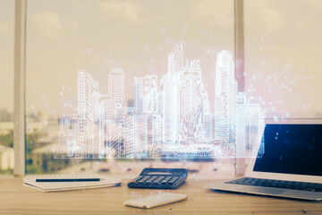 Desktop computer background in office and big town buildings hologram drawing. Double exposure. Smart city concept.