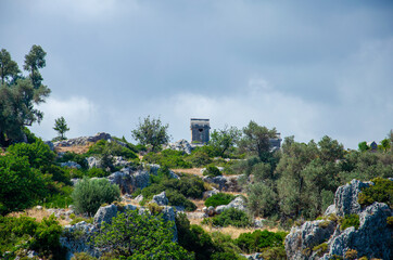 Ancient stone tomb on the island of Kekova in city of Simena, Turkey. Old concrete cemetery on the mountain. Sea tour of historical monument of architecture. Burial of ancestors closer to the sky