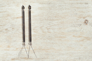 small vacuum glass electronic retro light bulb on the wooden background