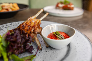 fried lamb ribs with tomato sauce and fresh greens