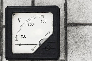 old vintage voltmeter on a gray surface