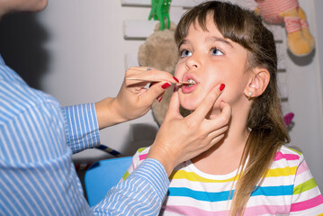 Young girl  in speech therapy office. Preschooler exercising correct pronunciation with speech therapist
