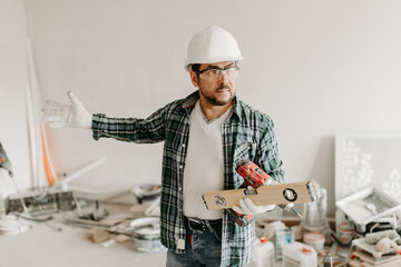 Builder with a tool points his hand to the side
