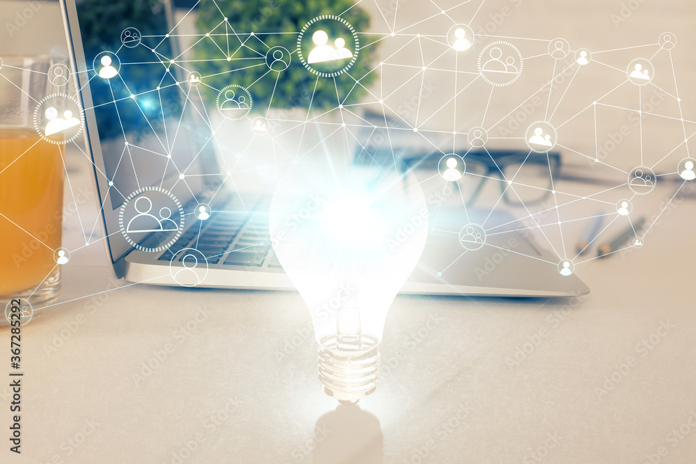 Poster computer on desktop in office with bulb icon hologram. multi exposure. concept of idea.