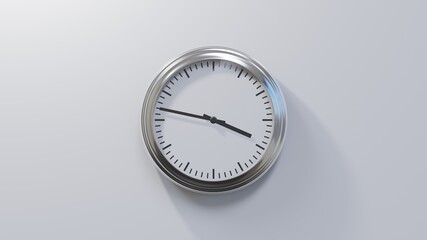 Glossy chrome clock on a white wall at forty-seven past three. Time is 03:47 or 15:47