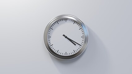 Glossy chrome clock on a white wall at twenty past four. Time is 04:20 or 16:20