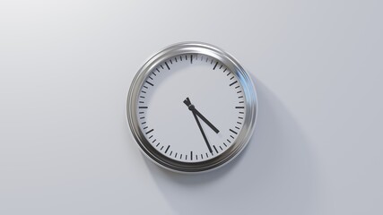 Glossy chrome clock on a white wall at twenty-six past four. Time is 04:26 or 16:26