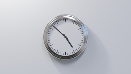 Glossy chrome clock on a white wall at fifty-two past four. Time is 04:52 or 16:52