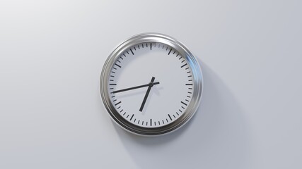 Glossy chrome clock on a white wall at forty-three past six. Time is 06:43 or 18:43