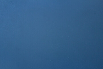 Blue textured background with some small white spots and dirt.