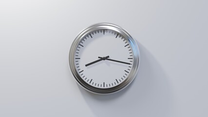 Glossy chrome clock on a white wall at seventeen past eight. Time is 08:17 or 20:17
