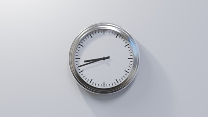 Glossy chrome clock on a white wall at forty-two past eight. Time is 08:42 or 20:42