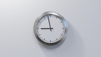 Glossy chrome clock on a white wall at fifty-eight past eight. Time is 08:58 or 20:58