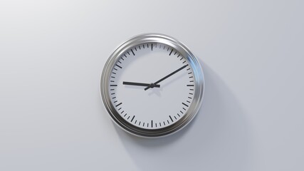 Glossy chrome clock on a white wall at ten past nine. Time is 09:10 or 21:10