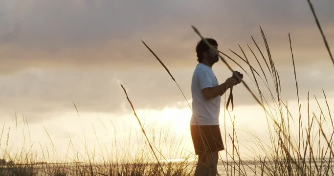 Silhouette of a male photographer taking photos during sunrise in nature