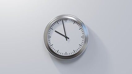 Glossy chrome clock on a white wall at fifty-eight past nine. Time is 09:58 or 21:58