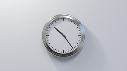 Glossy chrome clock on a white wall at twenty-four past ten. Time is 10:24 or 22:24