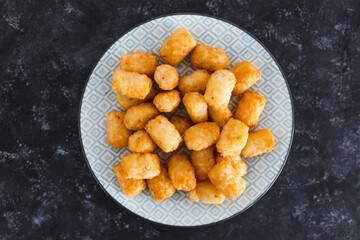 simple food ingredients, air fryed potato royals on small snack plate on dark background
