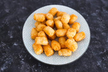 simple food ingredients, air fryed potato royals on small snack plate on dark background