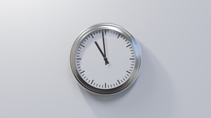 Glossy chrome clock on a white wall at fifty-nine past ten. Time is 10:59 or 22:59