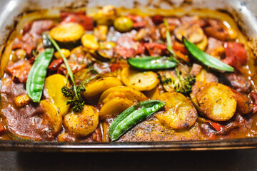 plant-based food, vegan tomato potato and snowpeas roasted in oven tray