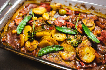 plant-based food, vegan tomato potato and snowpeas roasted in oven tray