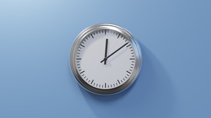 Glossy chrome clock on a blue wall at nine past twelve. Time is 00:09 or 12:09