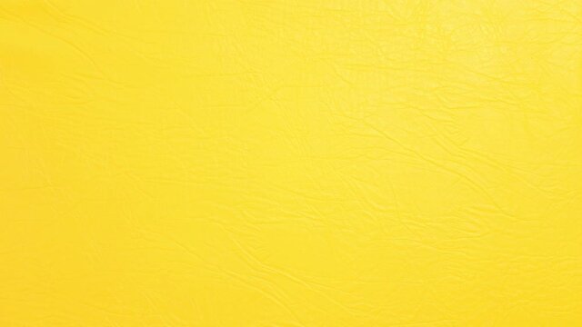 Texture of yellow leather surface, fabric for sewing furniture and other products. Camera is moving from up to down. Background for videos in sewing manufacturing.