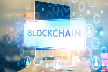 Multi exposure of blockchain theme hologram and table with computer background. Concept of bitcoin crypto currency.