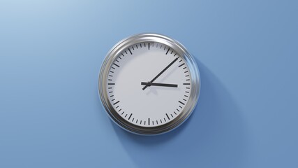 Glossy chrome clock on a blue wall at eight past three. Time is 03:08 or 15:08